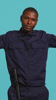 Vertical Security guard doing thumbs down sign gesturing, denying public access in restricted area. Portrait of bodyguard doing negative hand gesture, being dismissive, studio background, camera B video