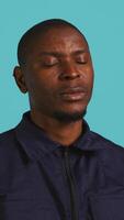 Vertical Portrait of security job employee yawning while at work detaining perpetrators, feeling tired. Patrol guard feeling exhausted after long night shift, isolated over studio background, camera B video