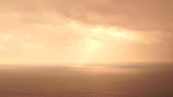 Beautiful rays of sun breaking through the clouds over calm sea ocean. Sunset over the Scenic seascape. Aerial view. Clear overcast background video