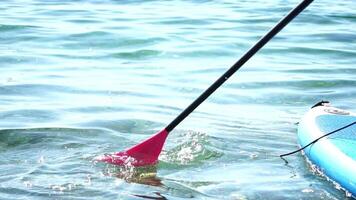 Man Sup Sea. Strong athletic man learns to paddle sup standing on board in open sea ocean on sunny day. Summer holiday vacation and travel concept. Aerial view. Slow motion video