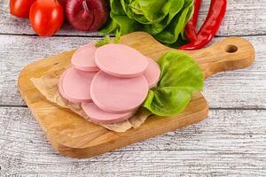 Slices boiled sausages for breakfast photo
