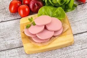Slices boiled sausages for breakfast photo