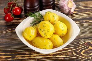 Boiled potato with oil and dill photo