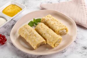 Homemade stuffed pancakes with honey and cream sour photo