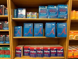 Herceg-Novi, Montenegro - 17 august 2023. Multi-colored dictionaries and grammars of French and English are on the shelves in the store photo