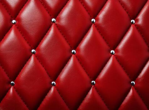 A close-up view of a luxurious red leather upholstery with decorative studs. photo