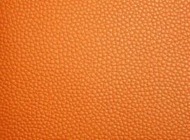 Close-up leather with a smooth, slightly uneven texture. photo