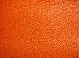 Close-up leather with a smooth, slightly uneven texture. photo