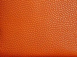 Close-up leather with a smooth, slightly uneven texture. photo