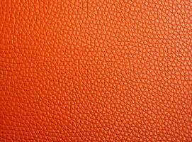 Bright orange leather texture with a slightly worn surface. photo