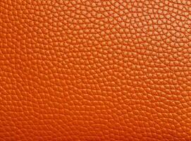 Bright orange leather texture with a slightly worn surface. photo