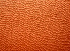 Close-up leather with a smooth, slightly uneven texture. photo
