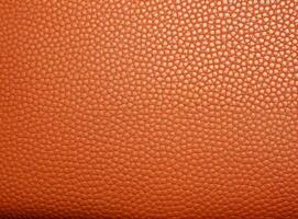 Close-up leather with a smooth, slightly uneven texture. photo