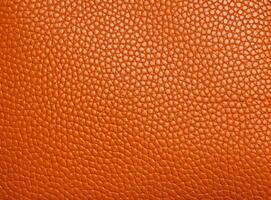 Bright orange leather texture with a slightly worn surface. photo