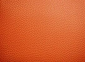 Close-up leather with a smooth, slightly uneven texture. photo