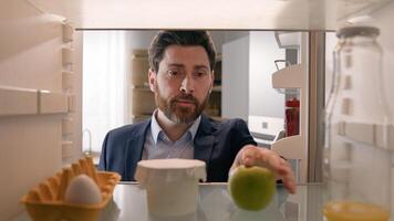 Point of view POV inside empty refrigerator Caucasian sad hungry businessman upset man open fridge with one egg empty bottle of juice searching snack take apple fruit diet need products food delivery photo