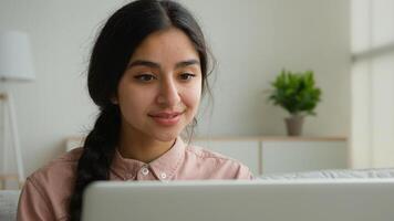 Happy Arabian woman student at home working with computer remote education e-learning write business project online studying with laptop Indian businesswoman girl make internet order surfing website photo