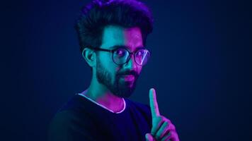 Ultraviolet neon background Arabian man hi-tech internet technology worker male coder computer hacker waving finger no not never reject deny negative attitude forbid system modern high-tech software photo