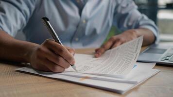 Close up male hands writing exam in class business paperwork with glass of water on office desk unrecognizable man businessman student studying write paper notes document text form insurance summary photo