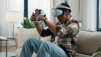 African American man in VR helmet glasses play game virtual reality experience metaverse playing computer gaming addiction having fun at home guy enjoy 3d cyber world online with controllers photo