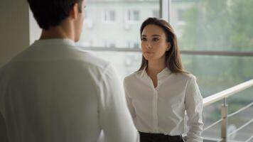 Business colleagues coworkers partners businesswoman smiling friendly pleasant formal conversation with unrecognizable businessman in office company talk together discuss project corporate deal talk photo