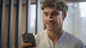 Caucasian smiling happy businessman walking in office looking at smartphone reading good news message business man smile go in company indoors hold mobile phone professional online communication chat photo