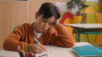 Little school boy primary schoolboy Caucasian son kid child clever smart writing task exercise at class lesson tired failure problem irritated trouble education difficulty hard studying learning study photo