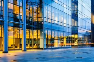 Modern office building windows lit in evening night early morning long working hours exhaustion overtime exterior urban architecture skyscraper lights tower financial sector banking hq photo