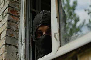 Burglar thief robbing house criminal activity robbery burglary mask crime scene stealing mugger security risk cctv camera catch illegal activity dangerous evil violence gun balaclava photo