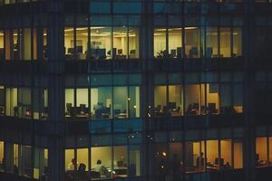Modern office building windows lit in evening night early morning long working hours exhaustion overtime exterior urban architecture skyscraper lights tower financial sector banking hq photo