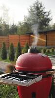 Red Portable Charcoal BBQ Grill Smokes Through Top video