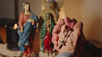 Hands Of Lady Praying Rosary And Statues Of Jesus Mary And Angel video