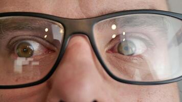 Closeup of hazel green eyes blinking, person in glasses blinking, iris and pupil, man at optician video