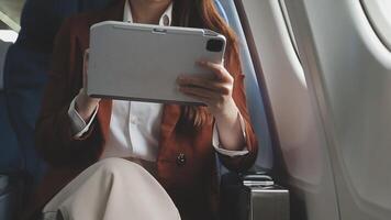 Traveling and technology. Flying at first class. Pretty young businees woman working on laptop computer while sitting in airplane. video