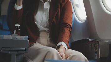 Attractive young asian businesswoman passenger taking pill of an airsick motion sickness before take off. Healthcare and transpiration concept. video