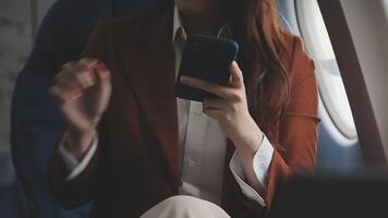 Woman using mobile phone in plane cabin video