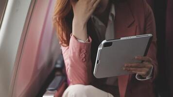 Traveling and technology. Flying at first class. Pretty young businees woman working on laptop computer while sitting in airplane. video