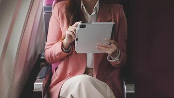 Traveling and technology. Flying at first class. Pretty young businees woman working on laptop computer while sitting in airplane. video
