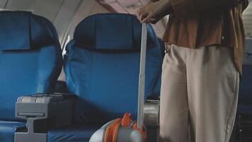 An Asian businesswoman in a semi-formal suit is using a tablet to read and analyze business data while traveling to a meeting in business class on a plane. video