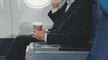 An Asian businesswoman in a semi-formal suit is using a tablet to read and analyze business data while traveling to a meeting in business class on a plane. video
