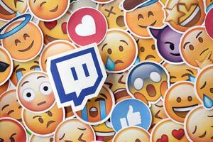 KYIV, UKRAINE - APRIL 20, 2024 Twitch logo and large set of stickers with Emoji yellow faces. Emoji is a pictogram or smiley embedded in text and used in electronic messages photo