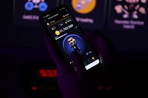 KYIV, UKRAINE - APRIL 20, 2024 Hamster Kombat telegram bot on smartphone screen. Hamster Kombat is a viral Telegram-based crypto game for earn HMSTR tokens by managing virtual crypto exchange photo