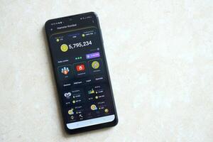 KYIV, UKRAINE - APRIL 20, 2024 Hamster Kombat telegram bot on smartphone screen. Hamster Kombat is a viral Telegram crypto game for earn HMSTR tokens by managing virtual crypto exchange photo