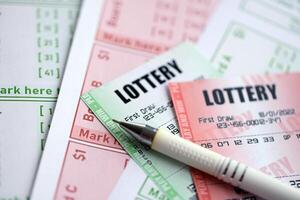 Green and red lottery tickets with pen on blank bills with numbers for playing lottery photo