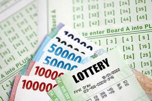 Green lottery tickets and indonesian money bills on blank with numbers for playing lottery photo