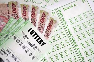 Green lottery tickets and Great Britain pounds money bills on blank with numbers for playing lottery photo
