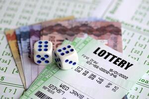 Green lottery tickets and brazilian reals money bills on blank with numbers for playing lottery photo