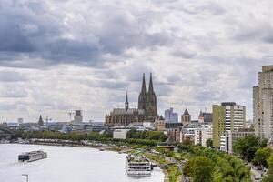 Cologne with a Rhine river running through it and a large cathedral in the background photo