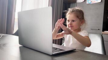 Cute little girl learning with online tutor at home. Child using computer app calling or watching online class lesson. Children education concept. High quality 4k footage video