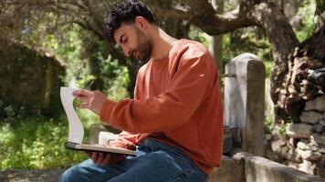 Philosopher Boy Thinks Seated Under The Olive Tree With Pencil And Notebook video